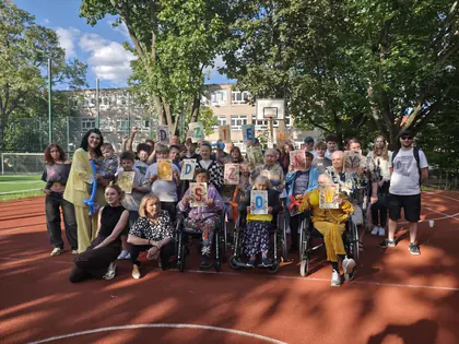Grupa młodzieży z rodzinami i seniorami pozuje do zdjęcia