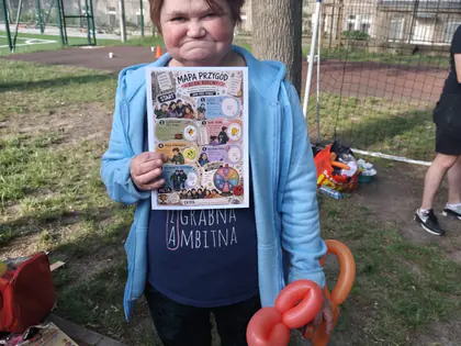 Mieszkanka z balonowym zwierzątkiem i ulotką na pikniku