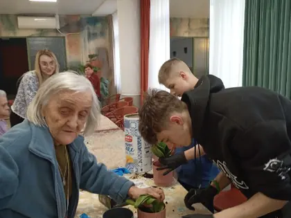 Mieszkanka i chłopak przesadzają kwiaty do doniczek