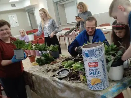 Mieszkańcy i młodzież przesadzają rośliny przy stole