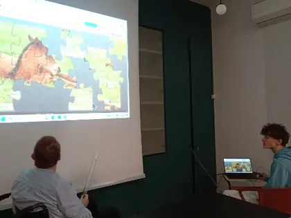 Kobieta na wózku wpatrzona w duży kolorowy ekran