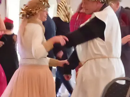 Para tańczy na balu, mężczyzna w białej todze i wieńcu laurowym