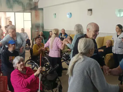 Sala z dużą grupą bawiących się starszych osób